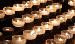 Rows of prayer candles light up the cathedral. (Photo by Tiffany Yu)